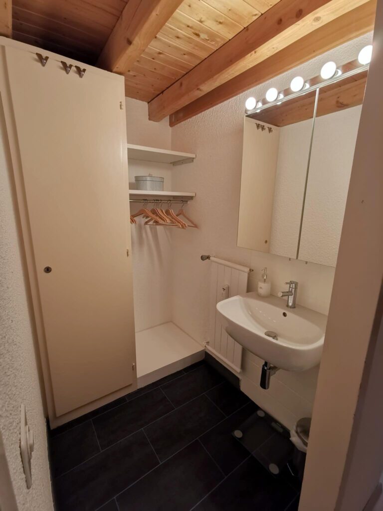 Chambre n°2 - Niche avec lavabo, penderie et rangements Location appartement Anzère, chambre lits simples et mezzanine lit double